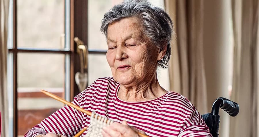 Lady sitting in a wheelchair with her knitting