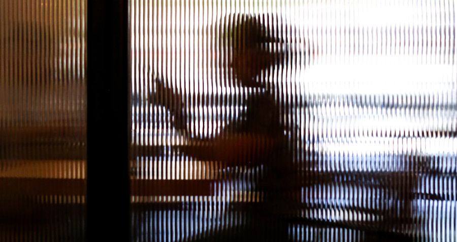 Woman using a screen behind opaque glass